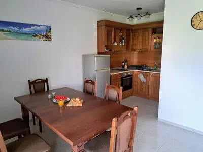 a kitchen with a wooden table and a refrigerator at Nessebar Apartment Pablo in Sunny Beach