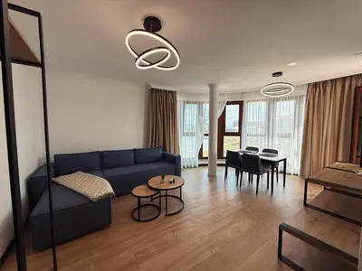 a living room with a blue couch and a table at Aparthotel Sveti Nikola in Pomorie