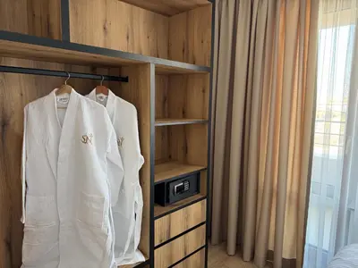 a room with a white robe hanging on a rack at Aparthotel Sveti Nikola in Pomorie