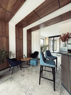 a living room with blue chairs and a table at Aparthotel Sveti Nikola in Pomorie