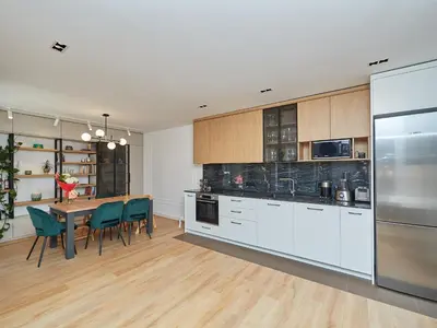 a kitchen with white cabinets and a table and chairs at n17 Garden - Parking - WorkDesk - Blackout Rolls- Netflix - Wash&Dry in Burgas City