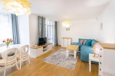 a living room with a blue couch and a table at Lidia Odrin by RV Apartments in Varna City