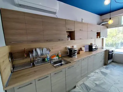 a kitchen with wooden cabinets and a sink at Хостел Спортна база Ветрен in Burgas City