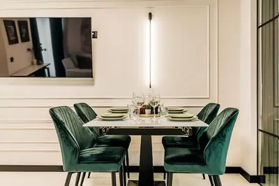 a dining room with a table and green chairs at The Loft - Parking - Washer&Dryer - Port view - Balcony in Burgas City