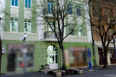 a green building with a tree in front of it at The Loft - Parking - Washer&Dryer - Port view - Balcony in Burgas City