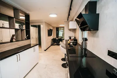 a kitchen with white cabinets and a black counter top at The Loft - Parking - Washer&Dryer - Port view - Balcony in Burgas City