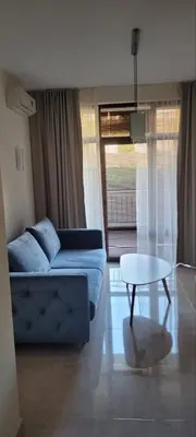 a living room with a blue couch and a table at Star Dreams P2 in Sveti Vlas