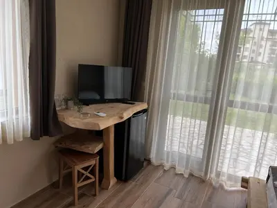 a room with a desk with a television and a window at Вилно селище Зора in Shkorpilovtsi