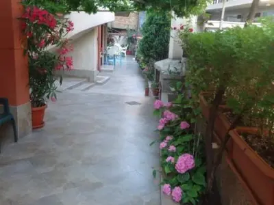 a walkway with flowers and plants in a building at Тихия кът in Sozopol