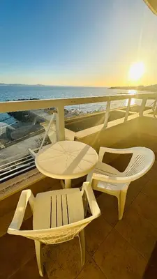 a balcony with a table and chairs and the ocean at Apartments Helios in Pomorie