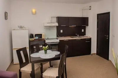 a kitchen with a table and chairs and a kitchen with a stove at Atlantis Resort Private 1BD apart by Flat Mаnager in Burgas City