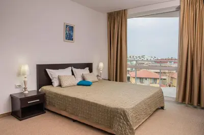 a bedroom with a large bed and a large window at Atlantis Resort Private 1BD apart by Flat Mаnager in Burgas City