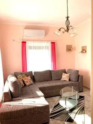 a living room with a couch and a glass table at Gemütliche Ferienwohnung zwischen Bergen und Meer in Orizare