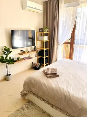 a bedroom with a bed and a flat screen tv at La Dahlia studio - Cascadas family resort in Sunny Beach
