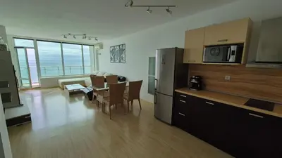 a kitchen and living room with a table and a refrigerator at Amazing panorama sea view apartment in Byala