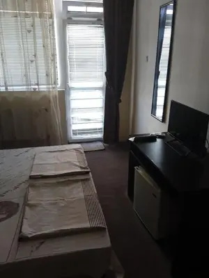 a room with a bed and a desk with a laptop at Къща за гости дани in Primorsko