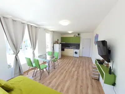 a living room with a bed and a table with chairs at Neptun-Blue in Primorsko