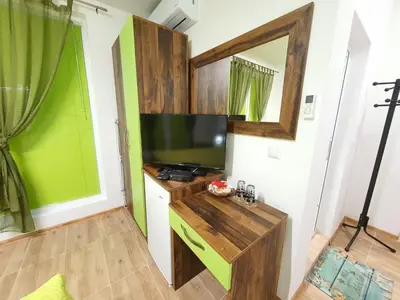 a living room with a flat screen tv on a wall at Neptun-Green in Primorsko