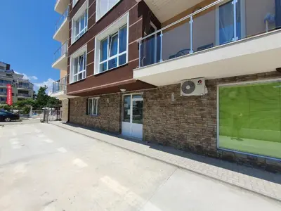 an empty street in front of a brick building at Neptun-Green in Primorsko