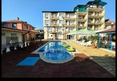 a large swimming pool in front of a building at Хотел Стоянови in Ravda