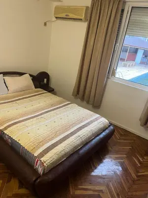 a bed sitting in a bedroom with a window at Хотел Стоянови in Ravda