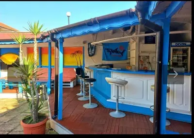 a bar in a rv with a kitchen on a deck at Хотел Стоянови in Ravda