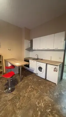a kitchen with a table and a sink and a washing machine at Studio paradise in Varna City