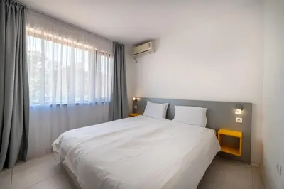 a bedroom with a large bed and a large window at Апартаменти с чадъри и шезлонги на плажа - Свети Никола Каваците in Sozopol