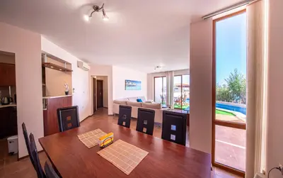 a dining room and living room with a table and chairs at Villa Belissima in Sveti Vlas