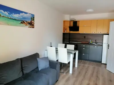 a living room with a couch and a table and a kitchen at Star Beach - Звезден плаж in Primorsko