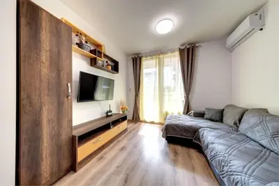 a living room with a couch and a flat screen tv at Star Beach - Звезден плаж in Primorsko