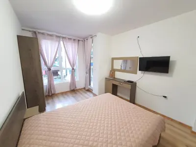 a bedroom with a bed and a flat screen tv at Star Beach - Звезден плаж in Primorsko