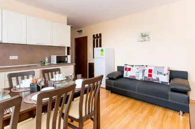 a kitchen and a dining room with a table and a couch at Oxygen Apartments in Sveti Vlas