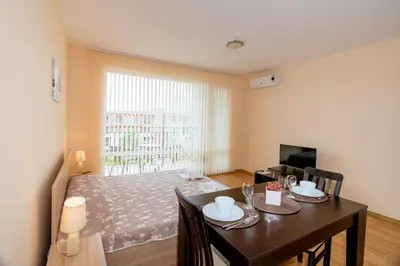 a room with a dining room table and a bed at Oxygen Apartments in Sveti Vlas