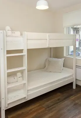 a bunk bed with white bunk beds in a room at Cozy & Functional by the Opera in Varna City