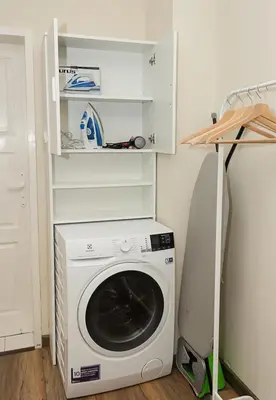 a washer and dryer in a room with a shelf at Cozy & Functional by the Opera in Varna City