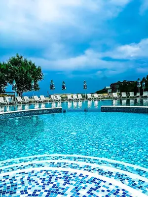 a large swimming pool with lounge chairs and blue at Hotel Oasis Del Mare in Lozenets