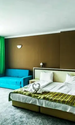 a bedroom with a bed and a blue couch at Hotel Oasis Del Mare in Lozenets