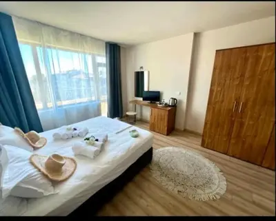 a hotel room with a bed with towels and a window at Къща за гости Беглик таш 3 in Primorsko