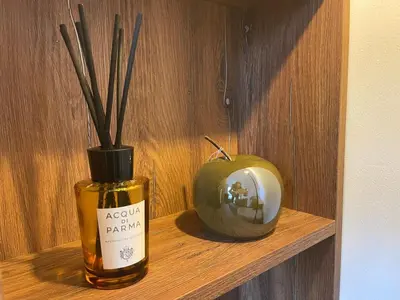 a shelf with a bottle and a vase with sticks in it at Luxury Sea nest next Marina Dinevi in Sveti Vlas