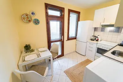 a kitchen with a table and a white refrigerator at Soleado in Burgas City