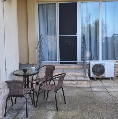 a patio with a table and chairs and a fireplace at Студио Бяла in Byala