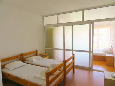a bedroom with two beds and a large window at Апартамент Съни Хаус - Sunny House Apartment in Byala