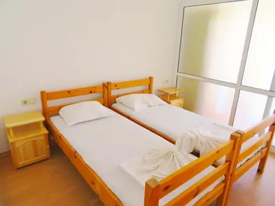 two wooden beds in a room with a window at Апартамент Съни Хаус - Sunny House Apartment in Byala
