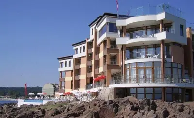 a large building on the beach next to the ocean at Sozopol Sunrise in Sozopol