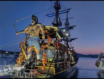 a statue of a man standing on the side of a ship at Sozopol Sunrise in Sozopol