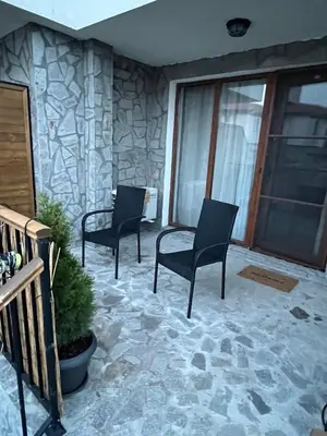 a patio with two chairs and a stone wall at Vineyard Spa Resort Aheloy - Muscat-6 Studio in Kableshkovo