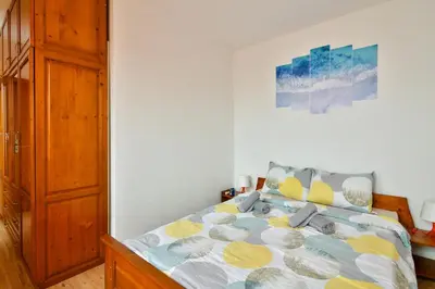 a bedroom with a bed and a painting on the wall at Roman Thermae, steps from the sea with free parking in Varna City