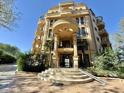 a large building with stairs in front of it at Menada Aphrodite Green Apartments in Sunny Beach