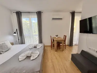 a bedroom with a bed and a television and a table at Menada Aphrodite Green Apartments in Sunny Beach